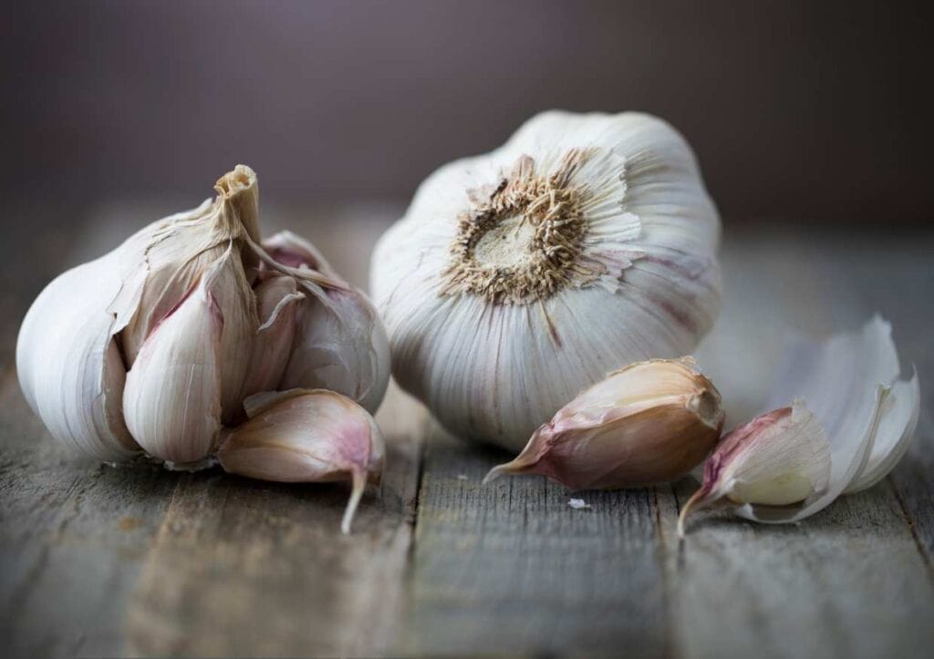 Two cloves of garlic on a wooden table.