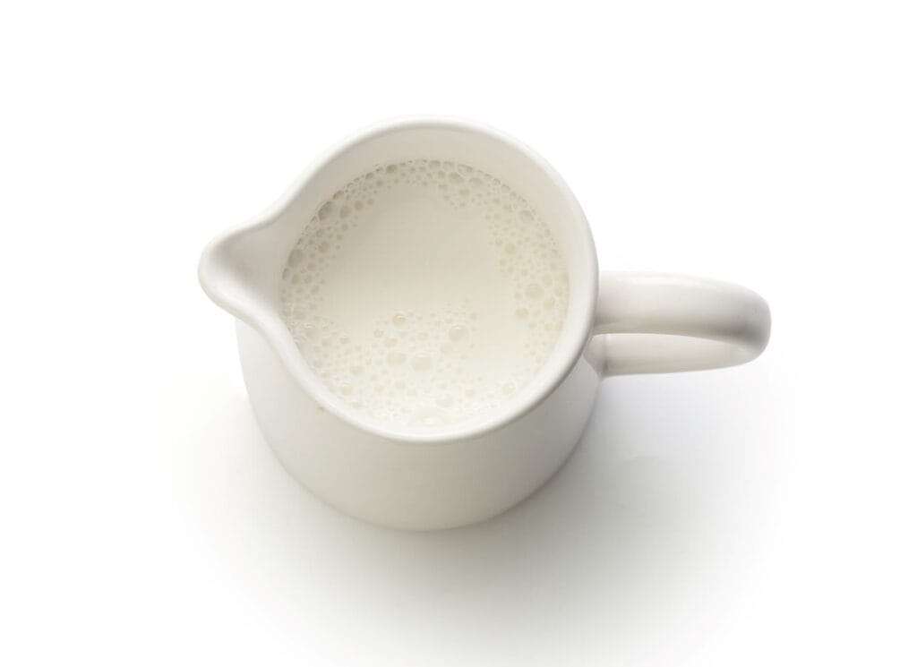A white jug of milk on a white background.