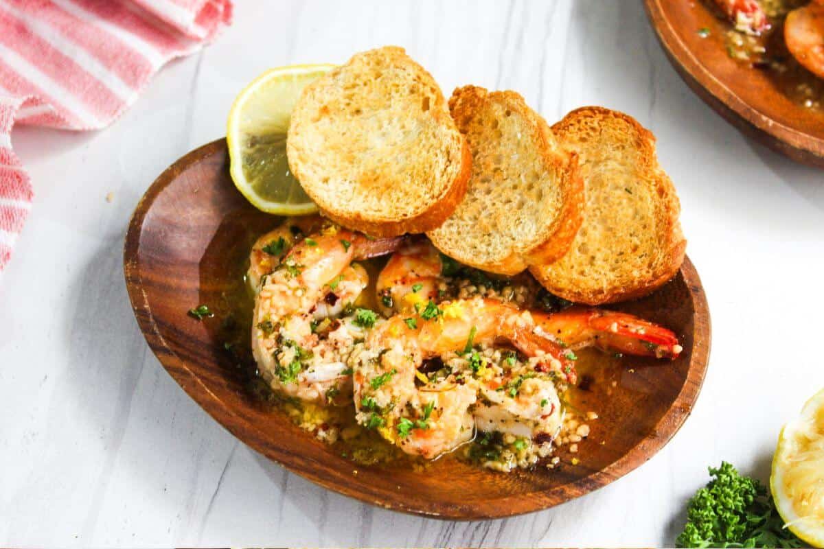 A plate with shrimp and bread on it.