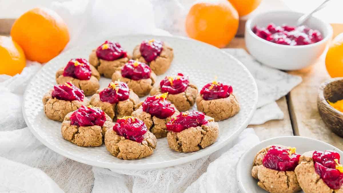 Cranberry orange thumbprint cookies on a white plate.