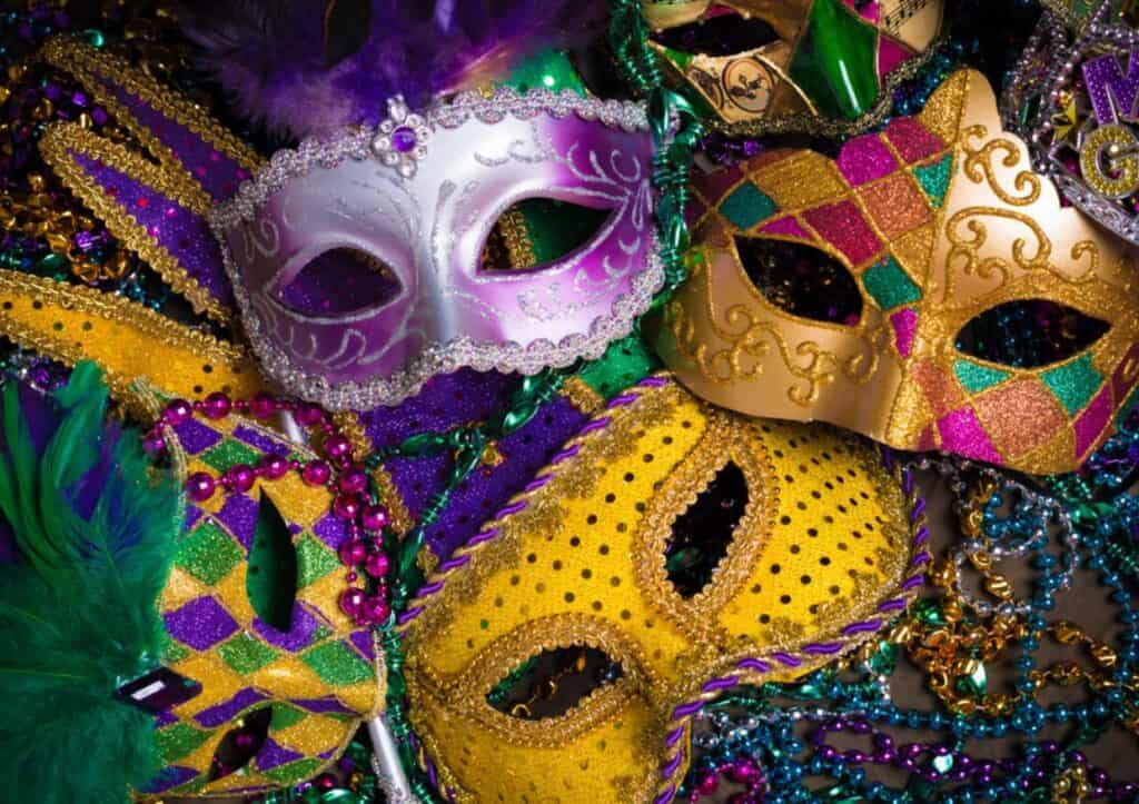 Mardi gras masks and feathers on a black background.