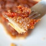 A piece of pecan pie on a fork.