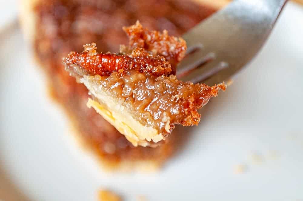 A bite of pecan pie on a fork.