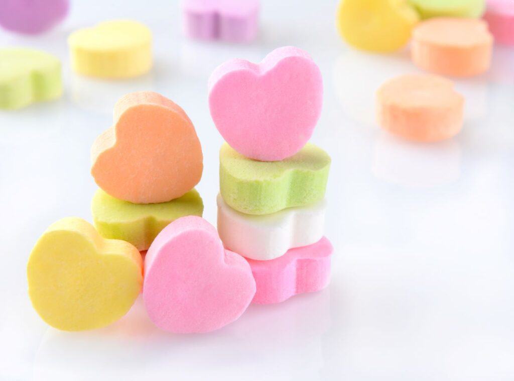 Colorful heart shaped candies on a white background.