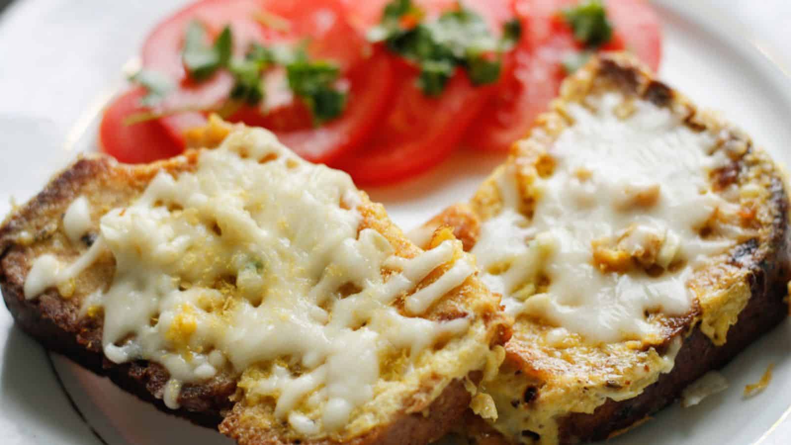 A slice of bread with cheese and tomatoes on a plate.