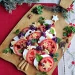 A wooden cutting board with a Caprese Christmas tree salad on it.