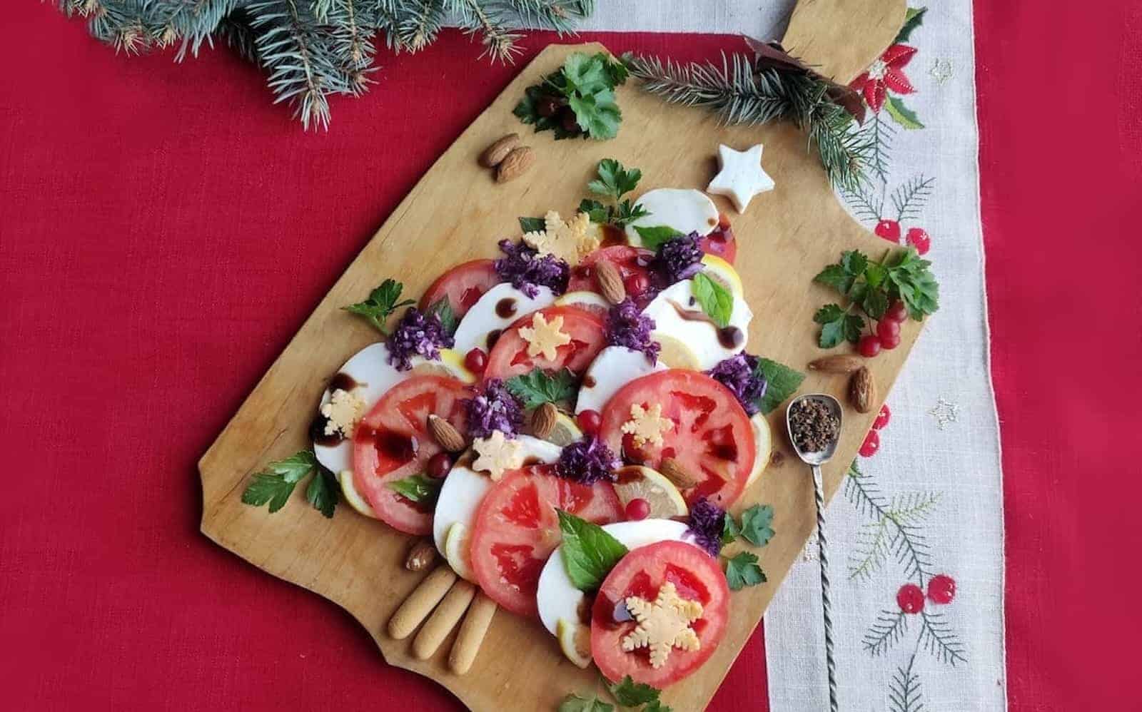 A wooden cutting board with a Caprese Christmas tree salad on it.