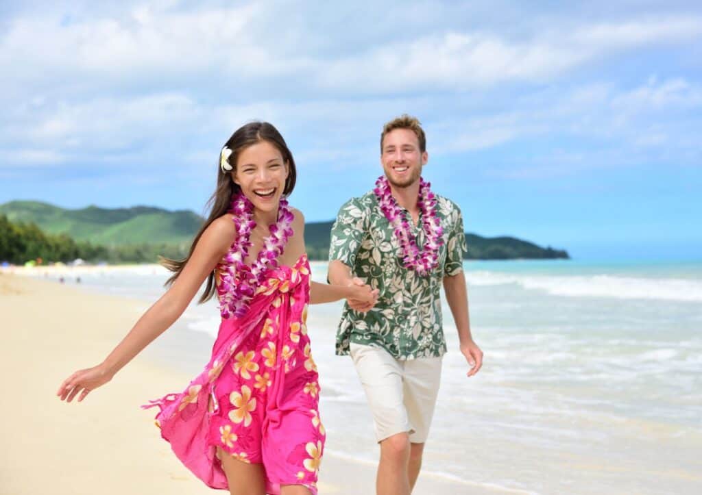 Hawaiian luau couple running on the beach.