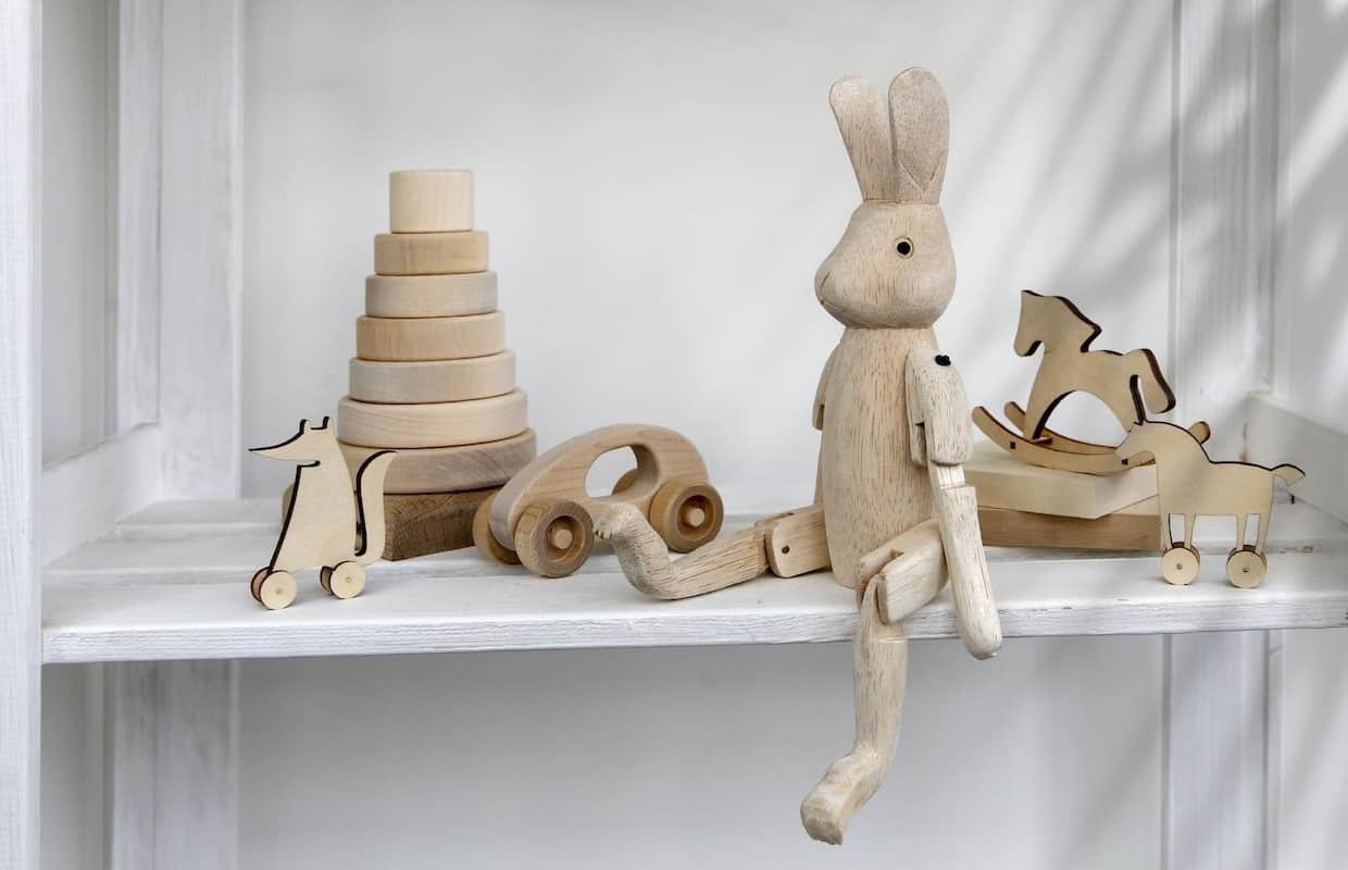 Wooden toys on a shelf with a rabbit and a car.