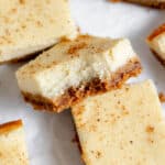 Pumpkin cheesecake bars on a white plate.