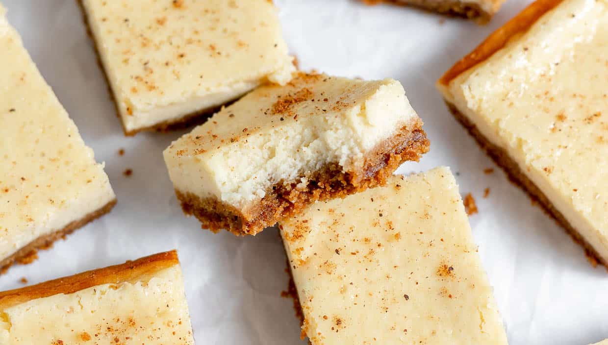 Eggnog Cheesecake bars one with a bite out of it.