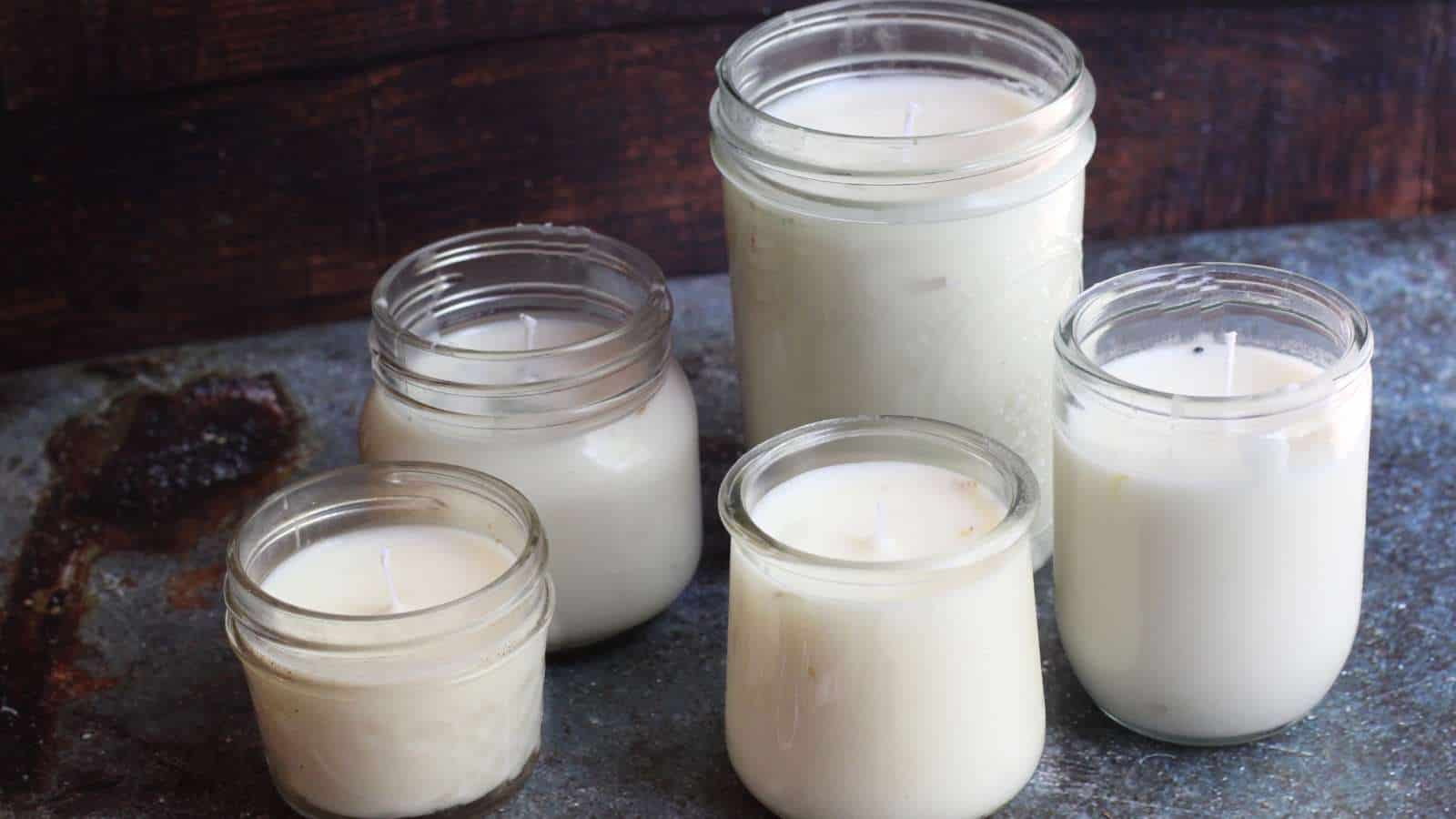 Four mason jars filled with white homemade emergency candles.