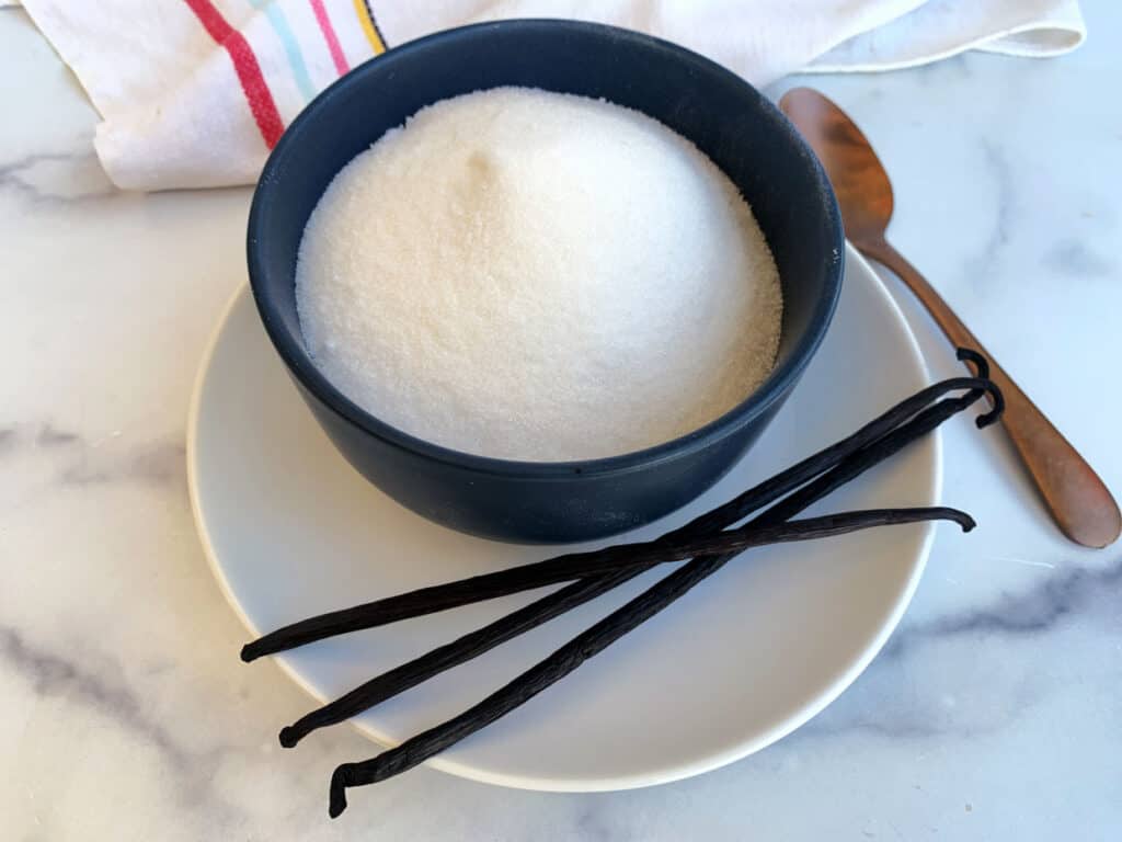 Vanilla sugar in a bowl on a white plate.