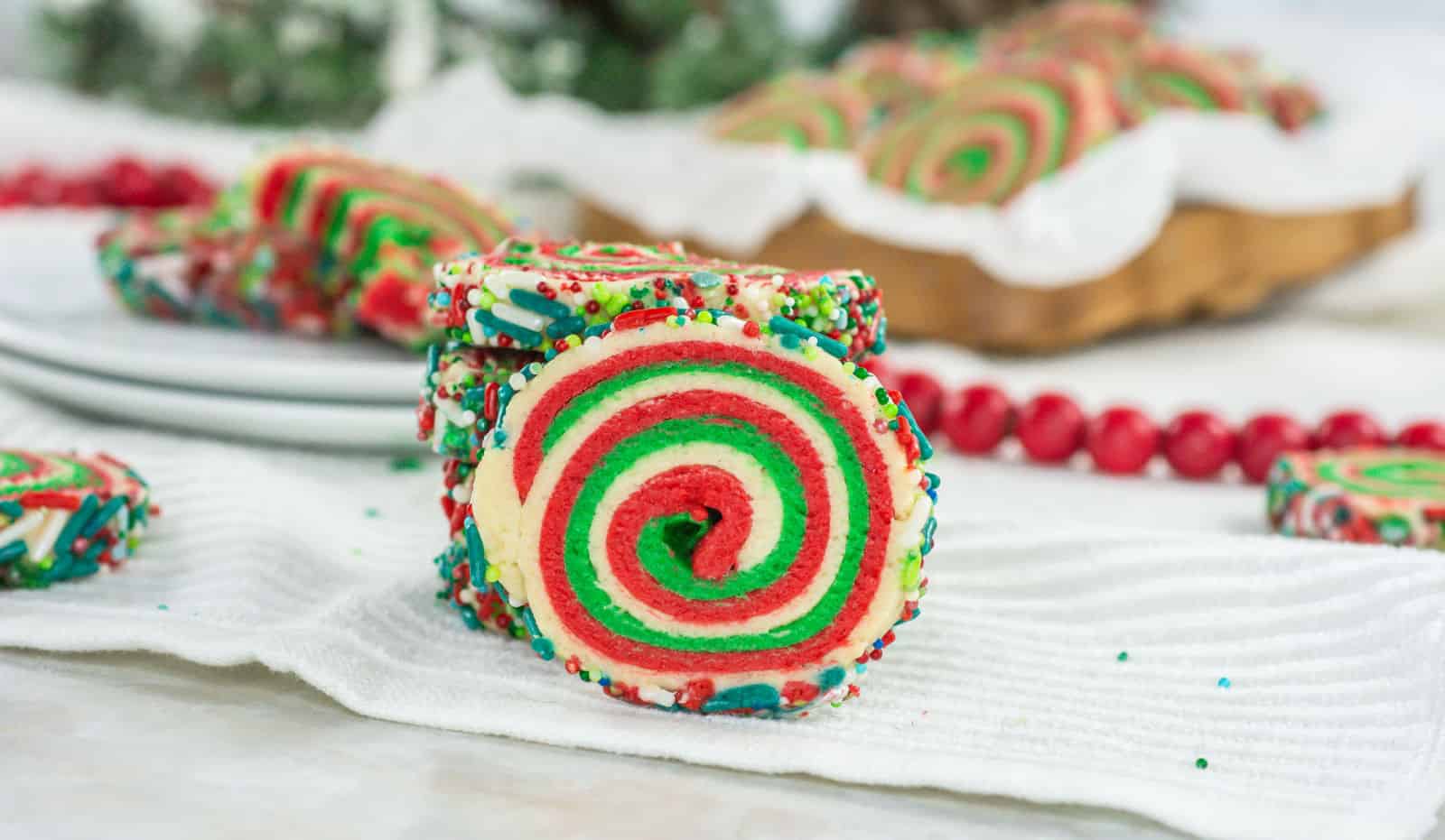 A stack of Christmas pinwheel cookies on a white table.