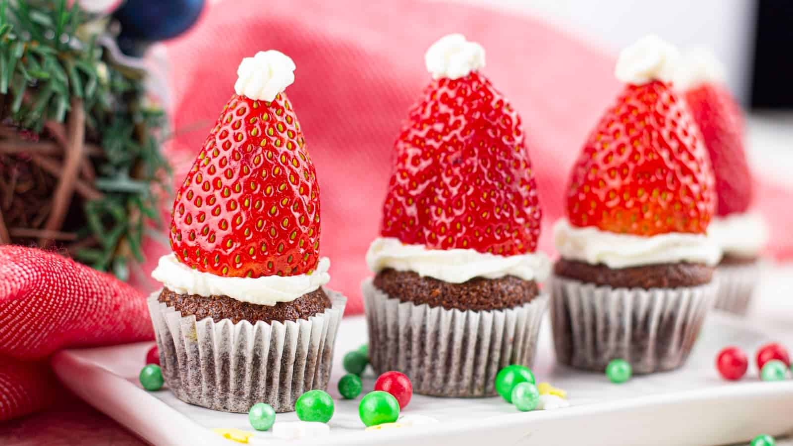 Santa hat mini Christmas muffins on a white plate. 