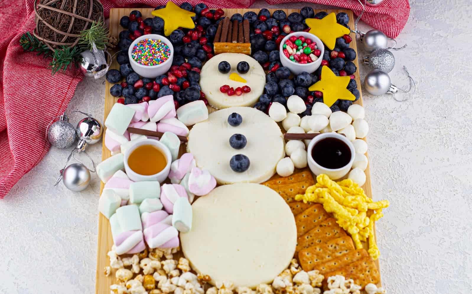 A snowman shaped platter of cheese and crackers.