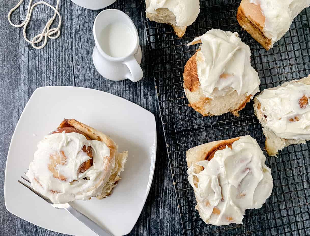Gingerbread rolls with cream cheese frosting on a plate.