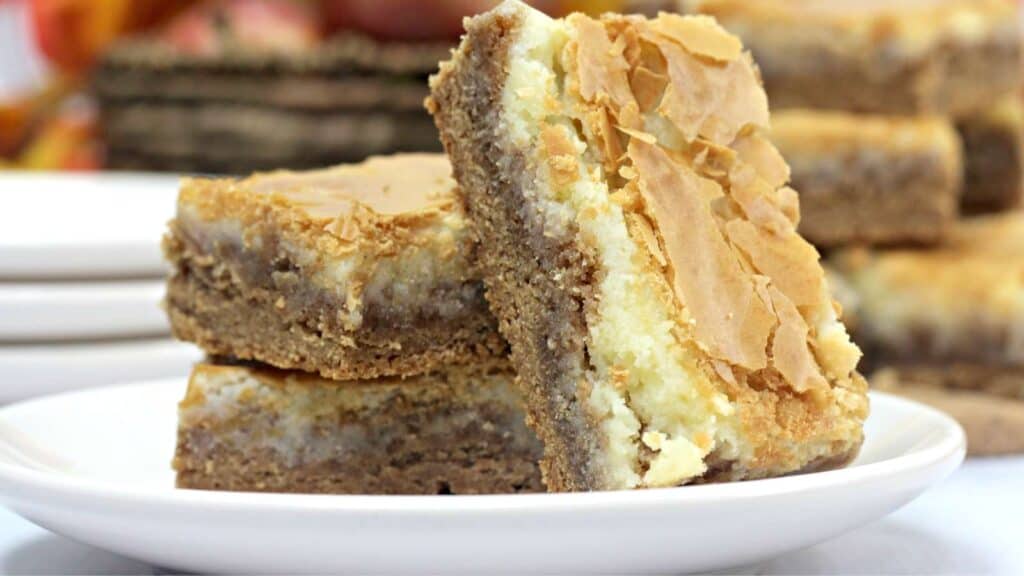 A stack of spice cake with cream cheese filling bars on a plate.