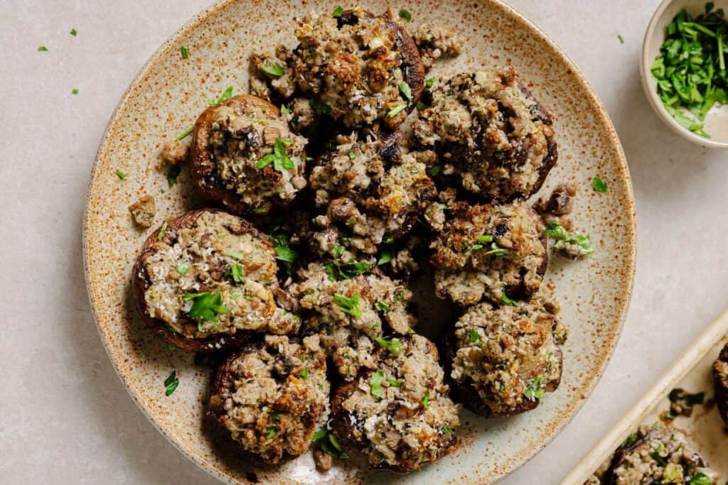 Stuffed mushrooms on a plate with parsley.