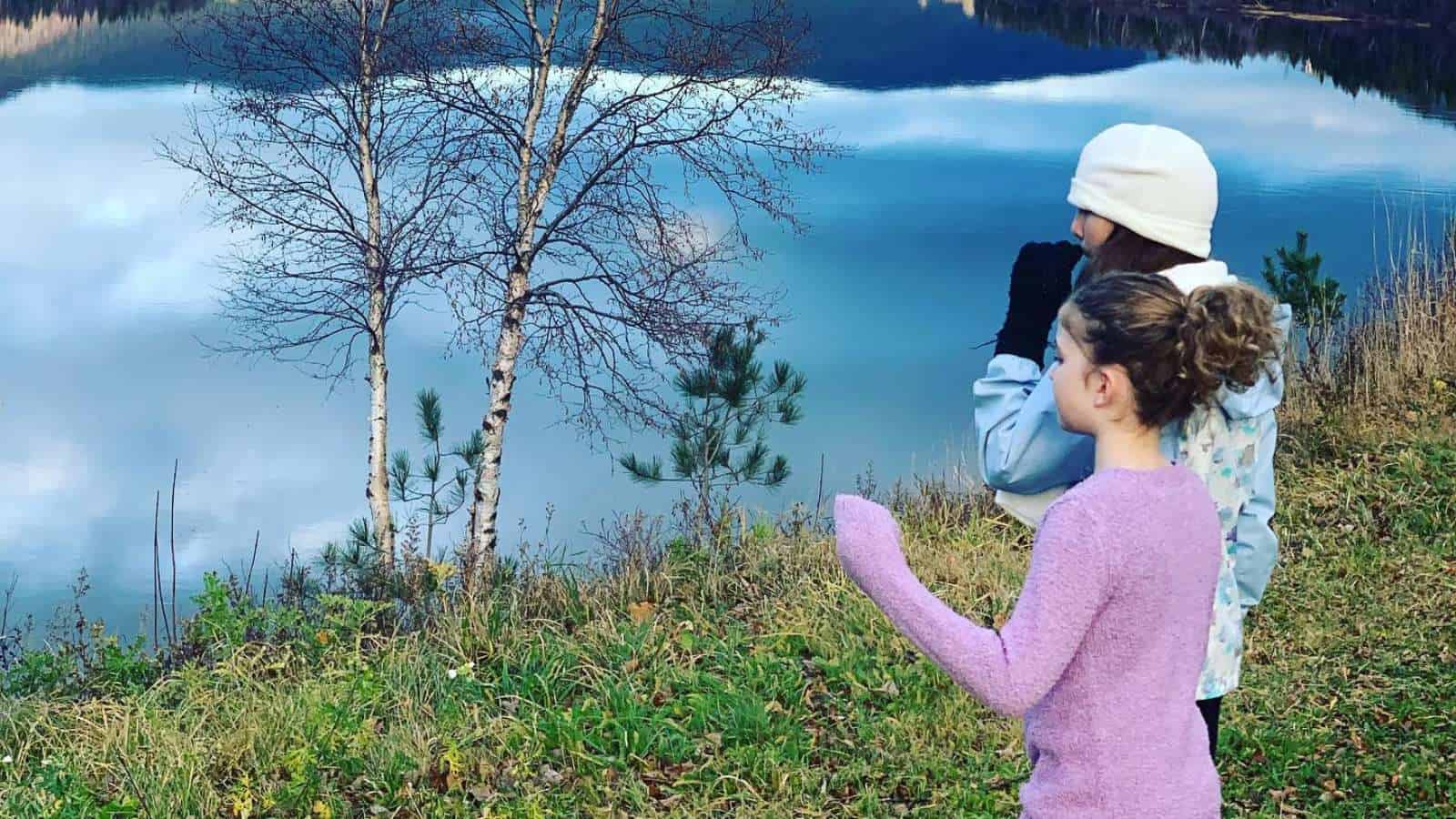 Two girls looking at a lake.