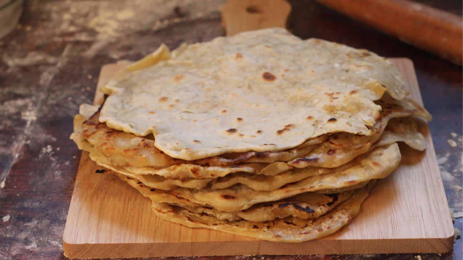 A stack of sourdough discard tortillas on a wooden cutting board.