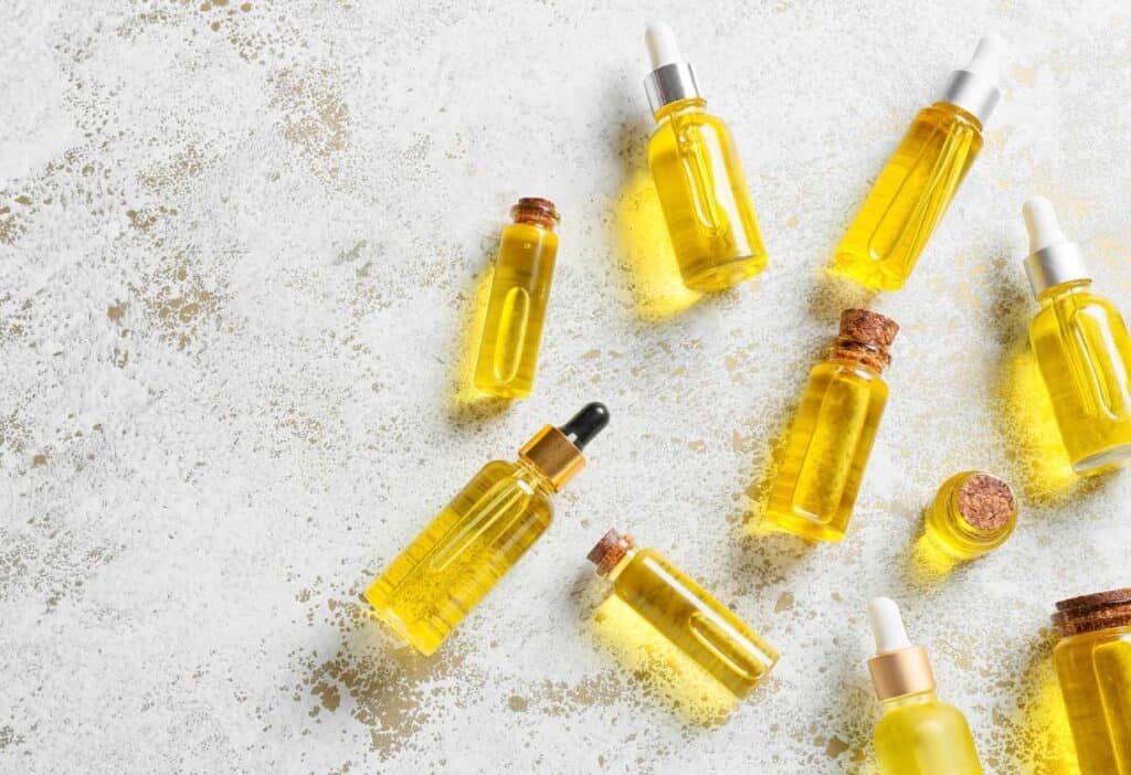 A group of yellow carrier oil bottles on a white background.