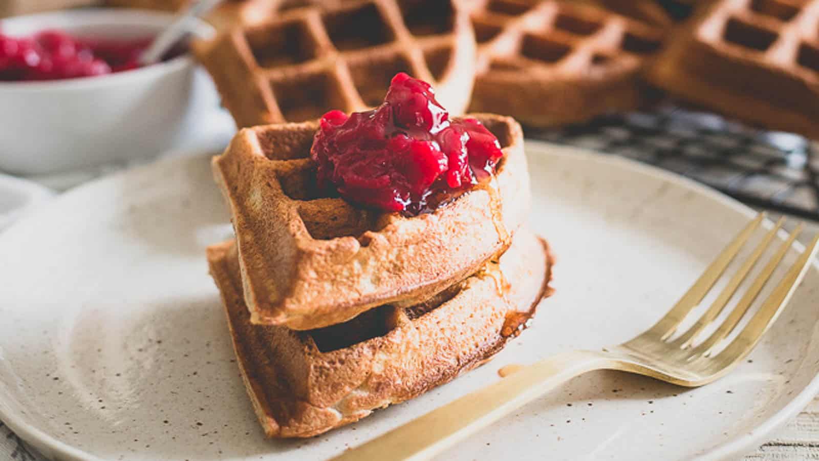Waffles with cranberry sauce on a plate.