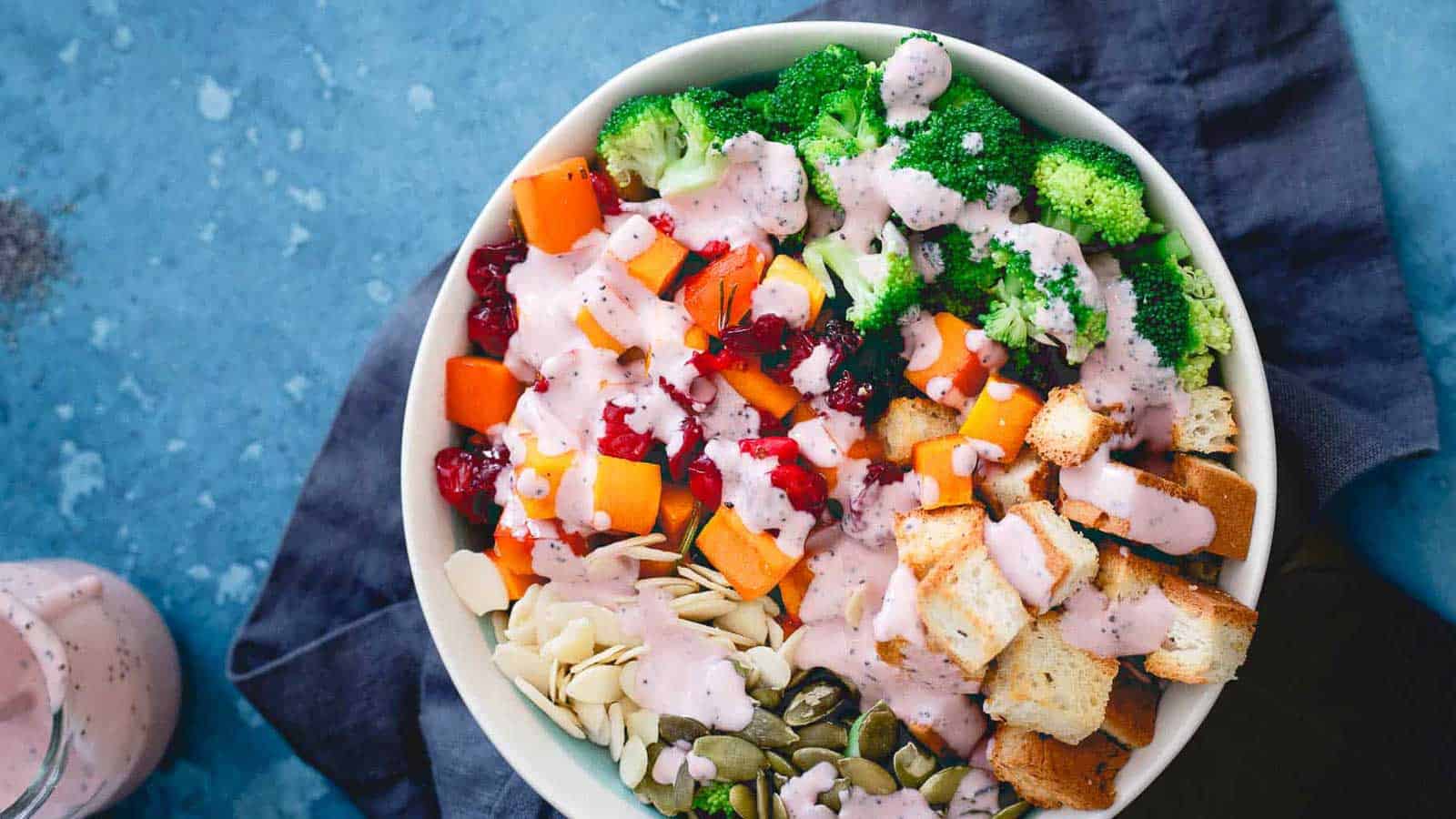 A bowl filled with broccoli, carrots and cranberries.