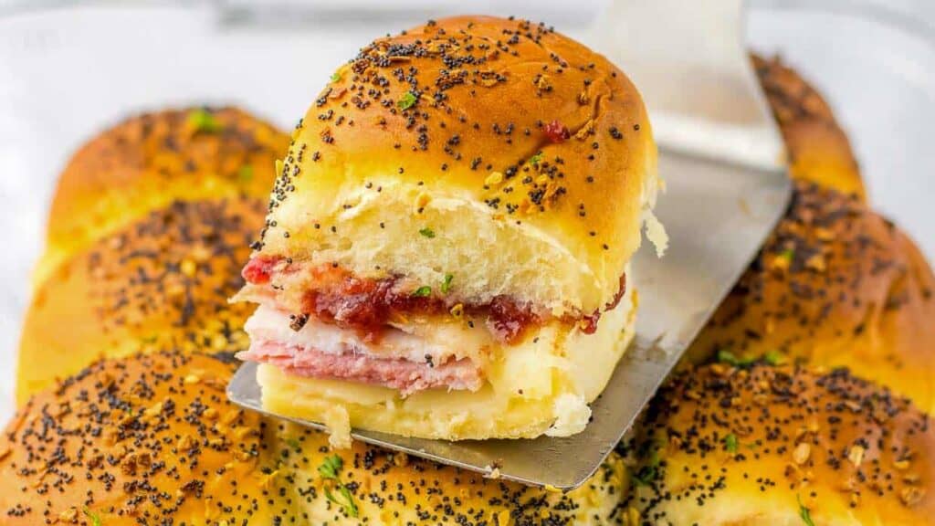 Ham and cheese sliders with a spoon in the middle.