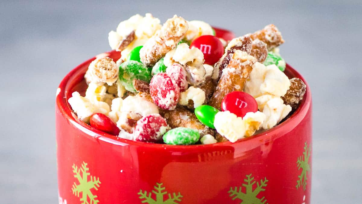 A bowl of popcorn with nuts and candy in it.