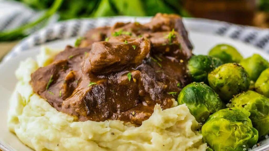 Beef stew with mashed potatoes and brussels sprouts.