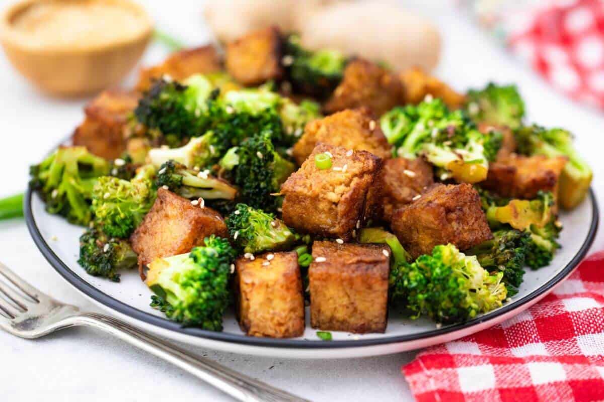Tofu and broccoli on a plate.