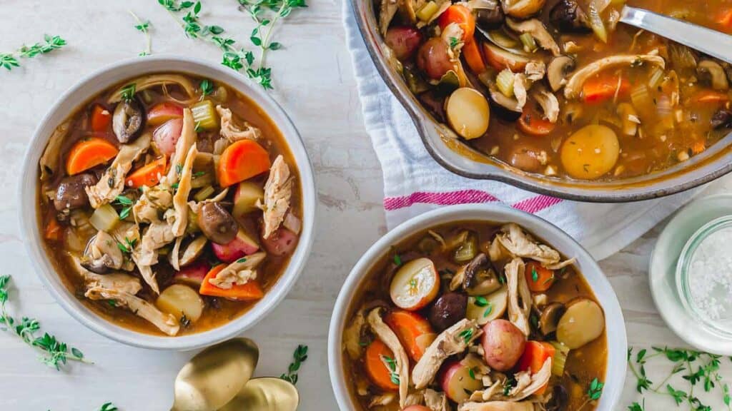 A bowl of turkey stew with carrots and potatoes.