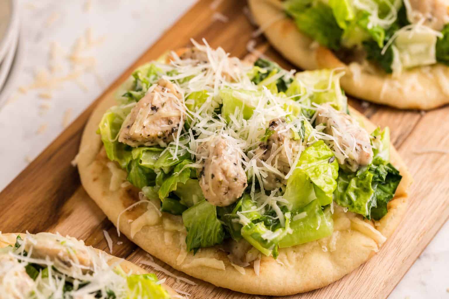 Small flatbread toped with salad and chicken.