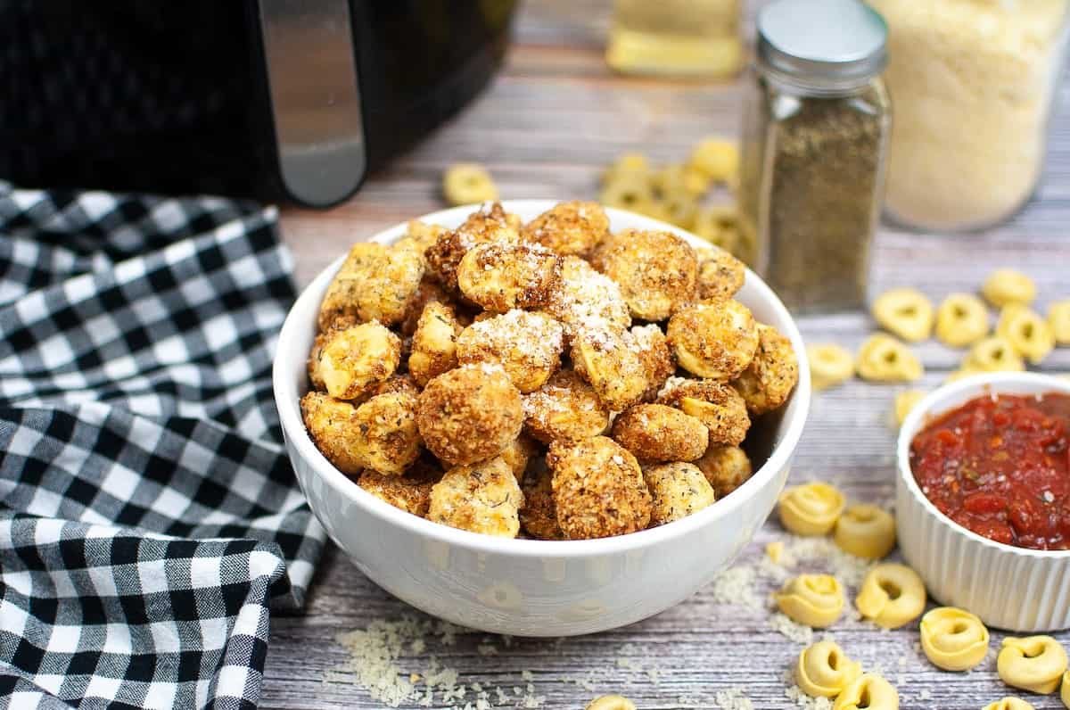 A bowl of tortellini in a white bowl.