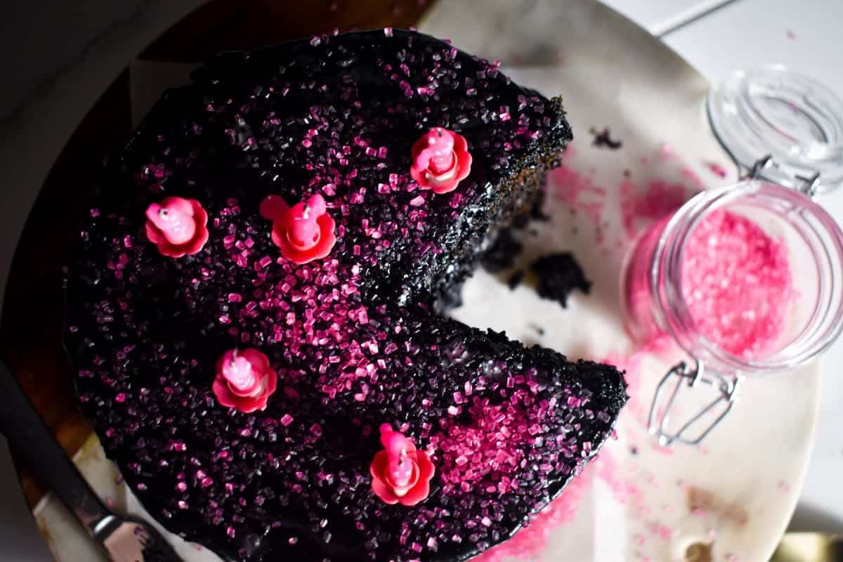 A Black Velvet cake with pink sprinkles on a plate.