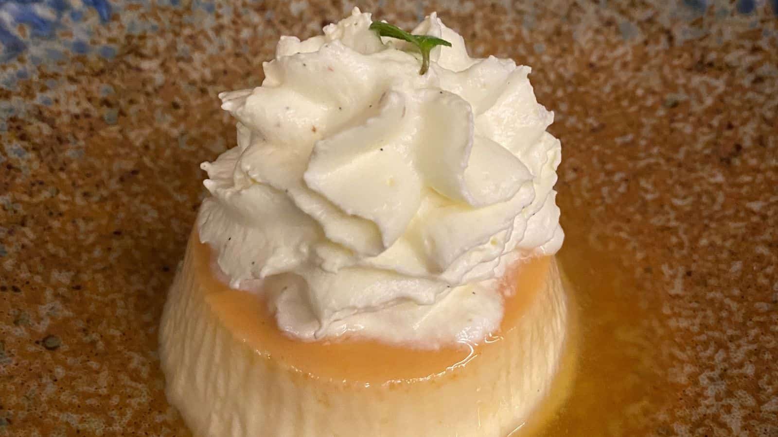 A dessert with whipped cream and a mint leaf on top.