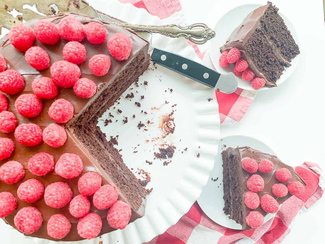 A chocolate cake with raspberries on a plate.