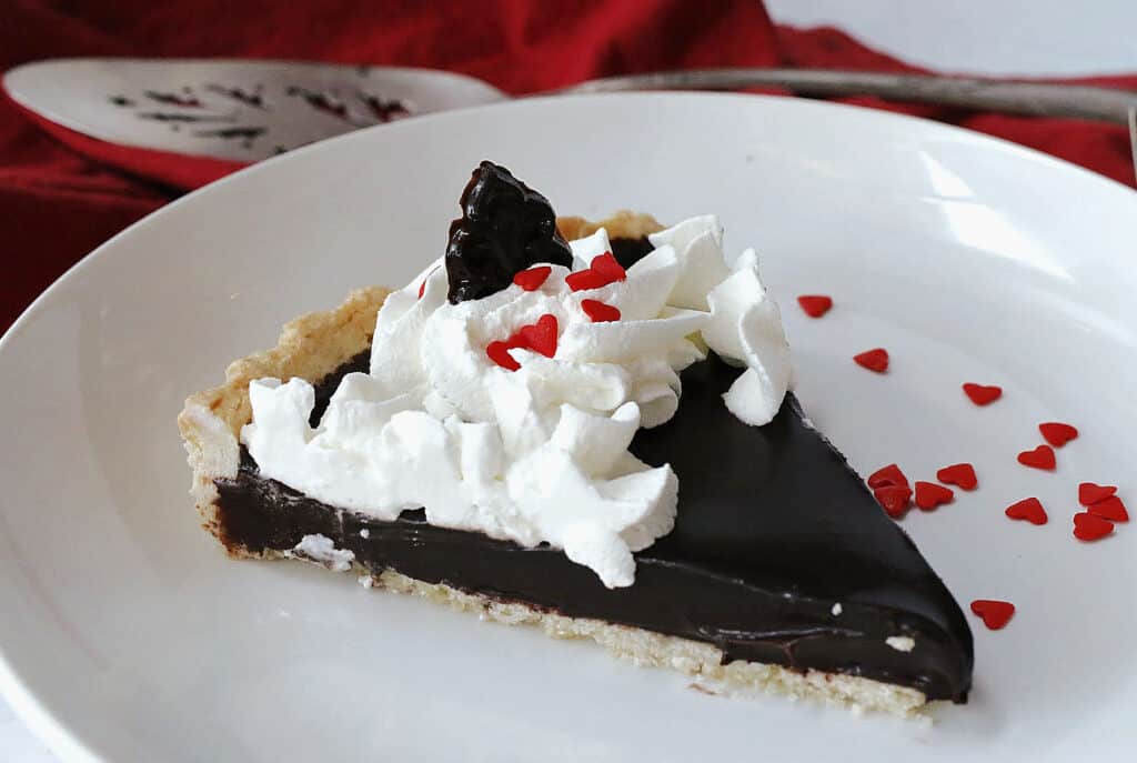 A piece of chocolate pie with whipped cream on a plate.