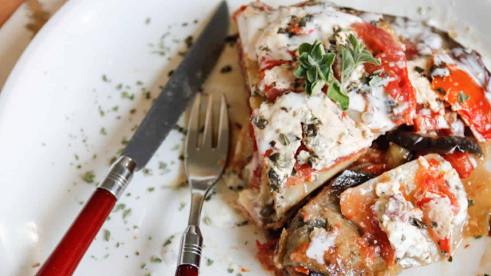 A plate with a slice of pizza and a fork.