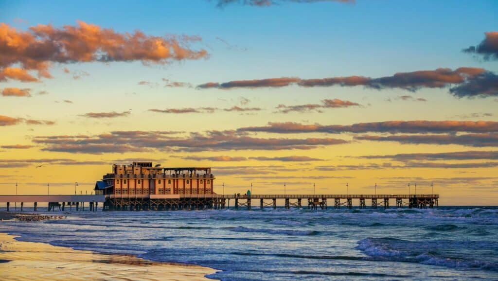 Experience the enchanting beauty of a beach pier at sunset in Daytona - one of the top things to do in Daytona Beach.