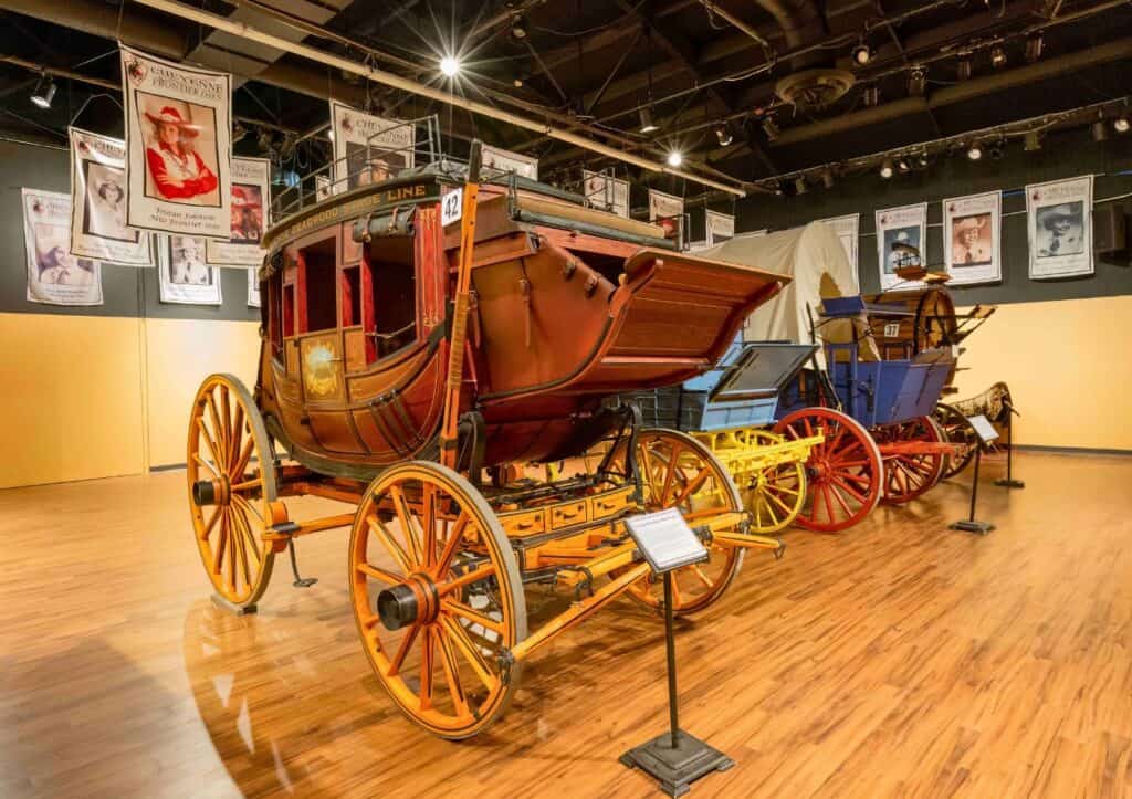 A horse drawn carriage is on display in a museum.