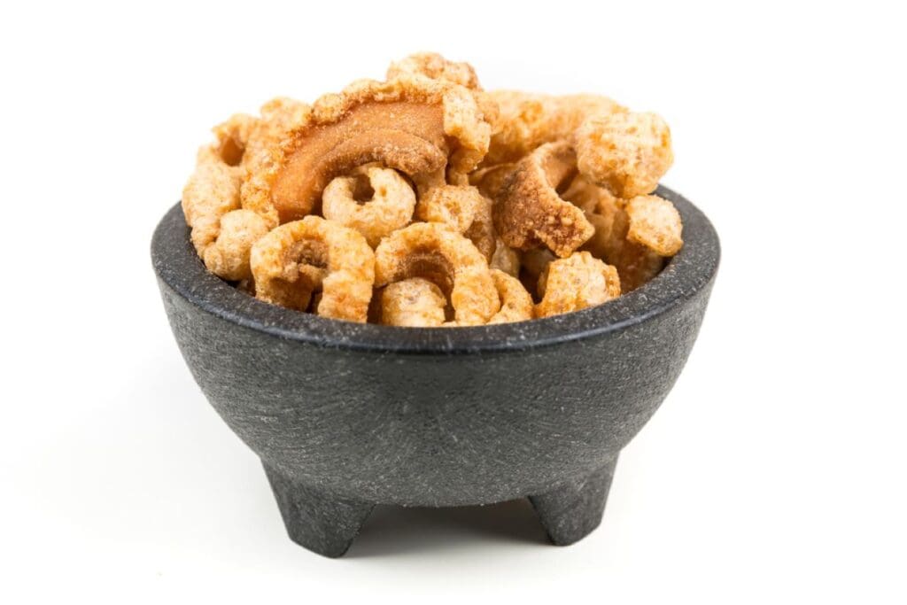 Pork rinds in a dark bowl.