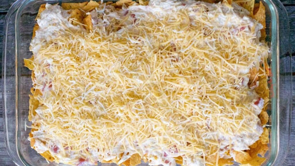 A casserole dish filled with nachos and cheese.