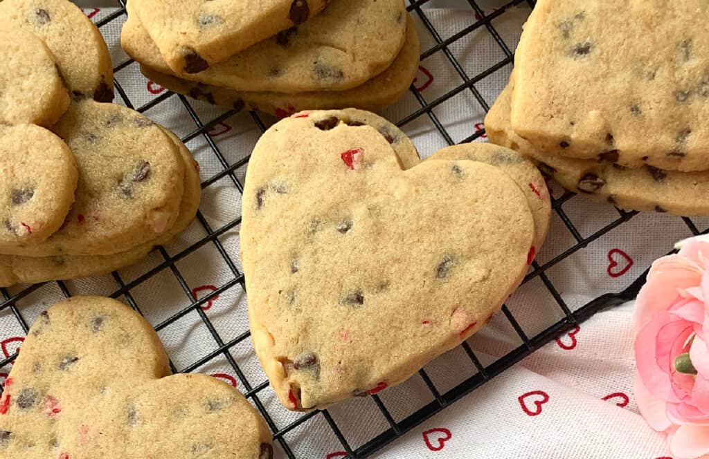 Heart shaped chocolate chip cookies on a cooling rack.