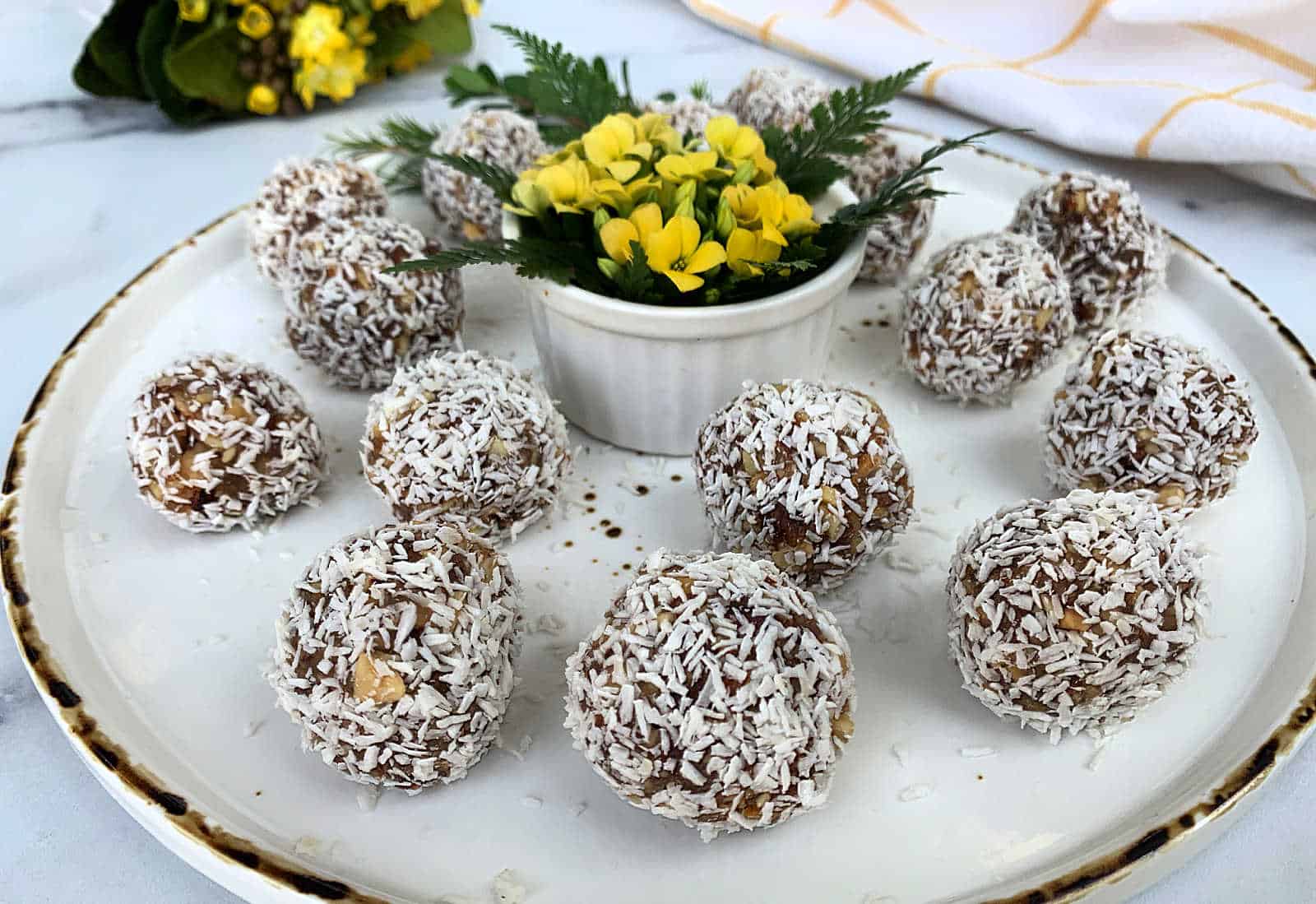 Coconut energy balls on a white plate.