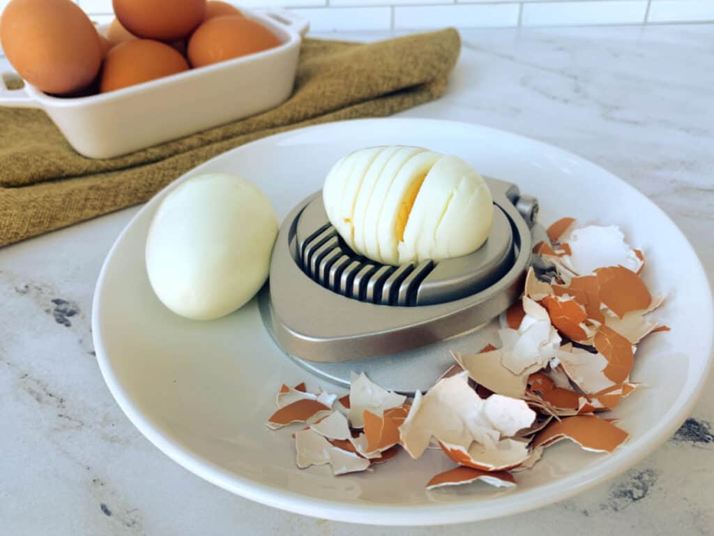 A plate with an egg and a grater next to it.