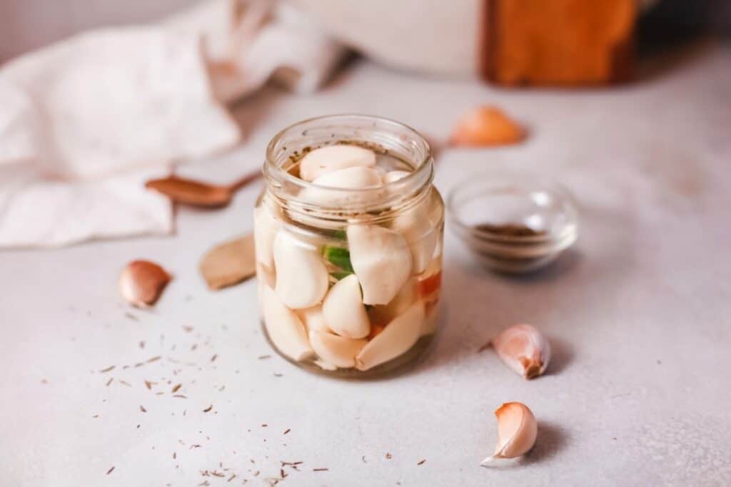Garlic in a jar on a table.