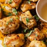 Chicken bites with garlic butter and herbs on a plate.