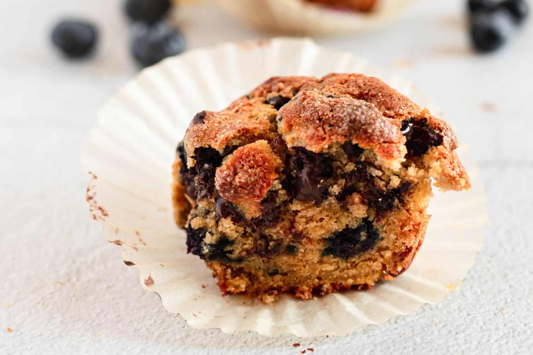 A blueberry muffin with a bite taken out of it.